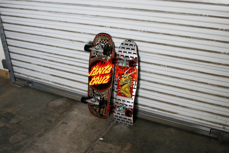 A Santa Cruz cruiser complete skateboard and a Powell-Peralta Caballero complete skateboard on the right.