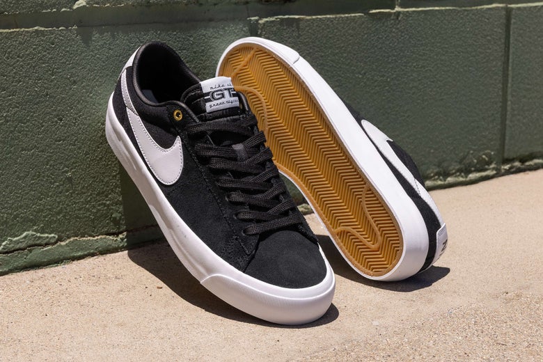 Nike SB Blazer GT shoes, leaned against a green wall