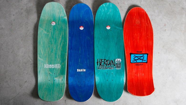 The top of four skateboard decks, varying in shape and size.